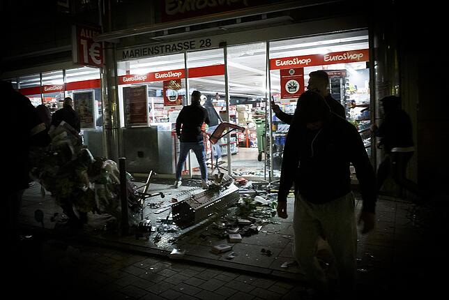 Randale und Plünderungen in Stuttgart Menschen stehen vor einem geplünderten Geschäft in der Stuttgarter Marienstraße.