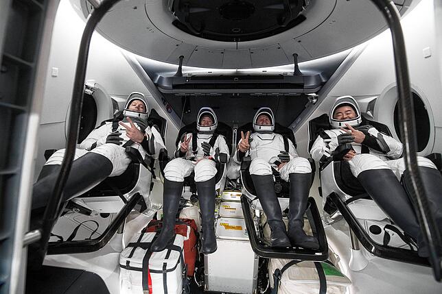 November 2021: Drei amerikanische und ein japanischer Astronaut geben in der Raumkapsel vor dem Abstieg zur Erde das Victory-Zeichen.