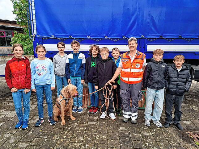 Schülerinnen und Schüler mit Andrea Iseli und Rettungshund Herrmann.