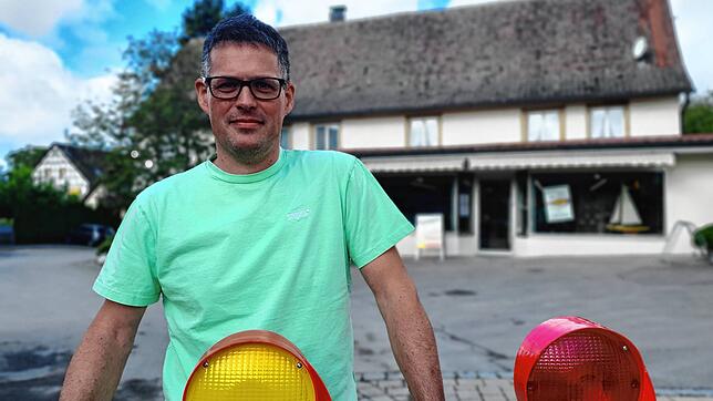 Vinzenz Weber, Inhaber einer Weinhandlung in Altheim, steht vor einer Absperrung, die sein Geschäft (im Hintergrund zu sehen) von der ...