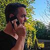 Markus Baur beim Telefonat im heimischen Garten.