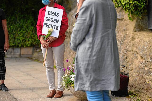 Die Schweigeminute mit &bdquo;Omas gegen Rechts&ldquo;-Schildern und weißen Rosen verwundert ein paar der vorbeifahrenden Radler. Für ...