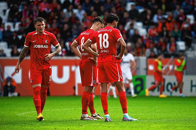Freiburgs Lukas Kübler, Maximilian Eggestein und Eren Sami Dinkci (l-r) stehen auf dem Spielfeld.