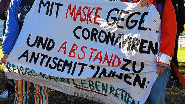 Während des Querdenker-Demonstrationswochenendes im Oktober 2020 in Konstanz halten bei einer Gegenveranstaltung zwei Demonstranten ein ...