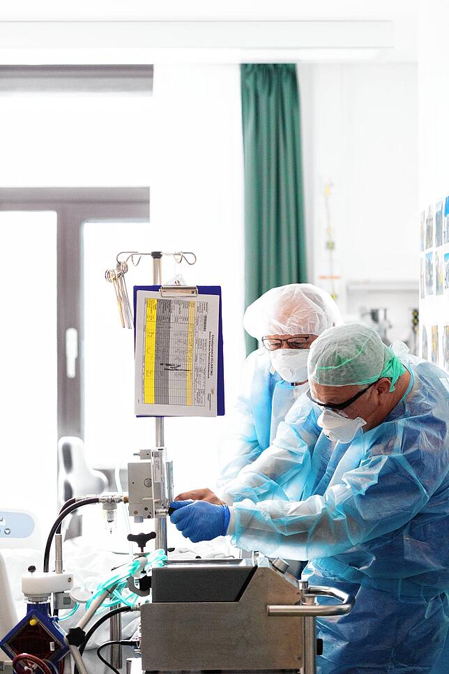 Pfleger kontrollieren die Einstellungen der Ecmo-Maschine, eine künstliche Lunge, ohne die viele Corona-Patienten nicht überlebt hätten.