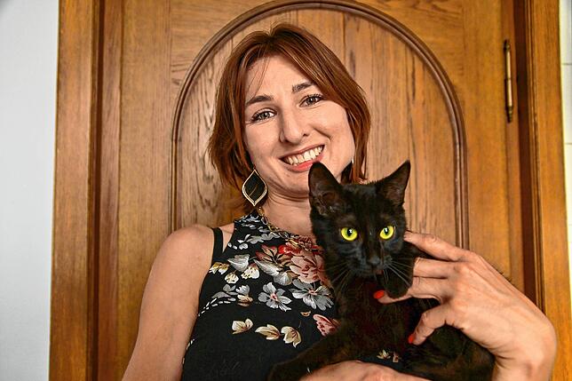 Cornelia Rettich mit einer etwa sechs Monate jungen Katze, die bei ihr auf ein neues Zuhause wartet.