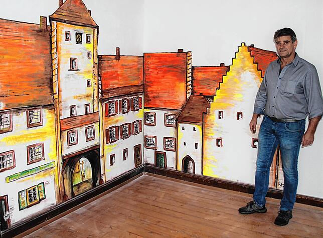 Zunftmeister Matthias Reichmann präsentiert das kunstvolle Wandgemälde von Wolfgang Kropfreiter. Es zeigt die Stadtmauer und das Stadttor.