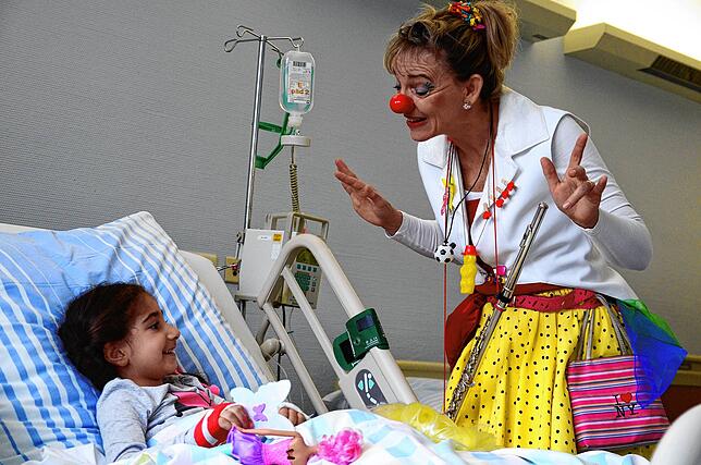 Kranke Kinder freuen sich auf ein paar unbeschwerte Momente, die ihnen Regina Lorenz als Klinikclown beschert.