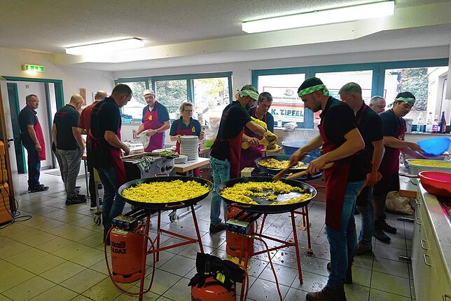 Der Vorsitzende der Trachtenkapelle Ralf Huber (Dritter von rechts) mit seinem fünfzehnköpfigen Team beim Vorbereiten des Brägelschmauses.