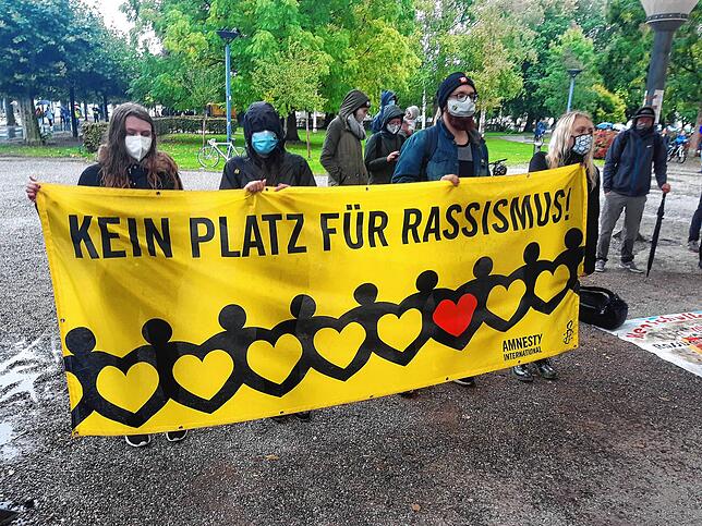 Im Stadtgarten zeigten diese Menschen mit Masken offen ihre Meinung über Rassisten zur Schau.