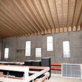 Diese Holzkonstruktion hält das leicht schräge Dach der Kelterhalle. Die unregelmäßig gesetzten Fenster sollen den Bau auflockern.