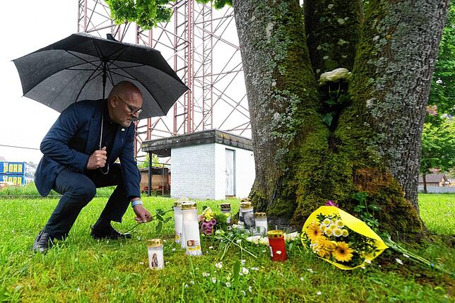 Winfried Hermann (Bündnis 90/Die Grünen), Verkehrsminister von Baden-Württemberg, legt eine weiße Blume in der Nähe der Unglücksstelle ab.