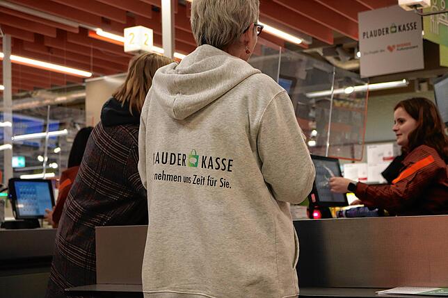 An den Pullovern erkennen Kunden die Ehrenamtlerinnen im Geschäft. Meist helfen sie beim Einpacken der Einkäufe und kommen so ins Gespräch.