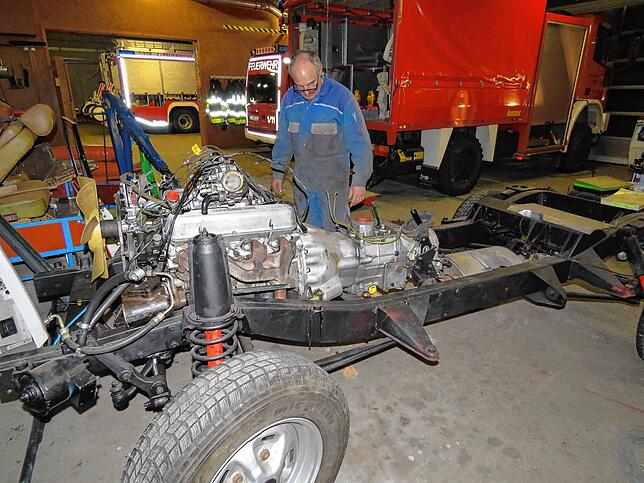 Zerlegt wurde der Range Rover als die Restaurierung begann. Zu sehen sind Fahrgestell und Motor, Bernhard Waldvogel mustert den Rahmen.