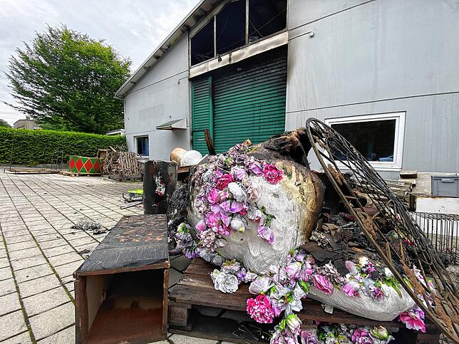 Nach dem Brand in einer Lagerhalle in Reichenau-Waldsiedlung: Das Gebäude ist erheblich beschädigt, und zerstörte Deko-Artikel liegen ...