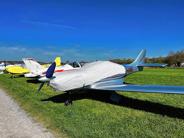 Eingepackt für die Nacht. Viele Flugzeuge stehen zugedeckt und geparkt auf dem Rollfeld in Markdorf.