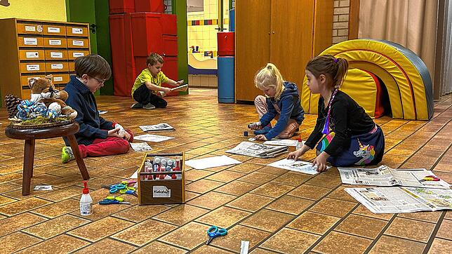 Ben, Jan, Lea und Leonie (von links) blättern die Zeitung auf der Suche nach Fotos durch.