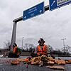 Klimaaktivisten der Gruppe &bdquo;Aufstand der letzten Generation&ldquo; sitzen auf der Fahrbahn der Autobahn A100 bei Berlin, um gegen ...