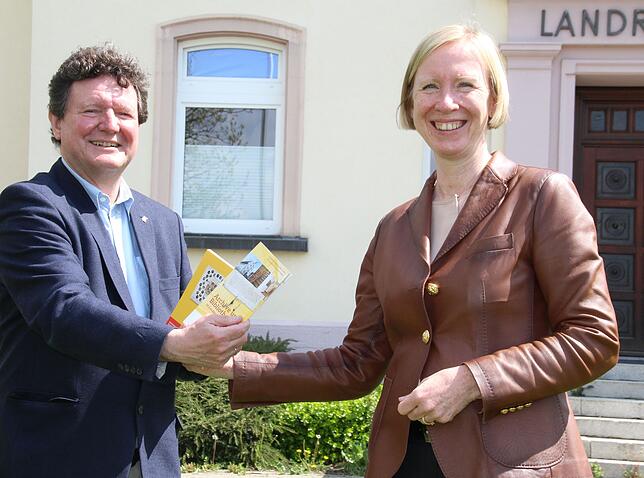 Kreisarchivar Edwin Weber übergibt Landrätin Stefanie Bürkle das Programmheft zum Kulturschwerpunkt 2022 im Landkreis.