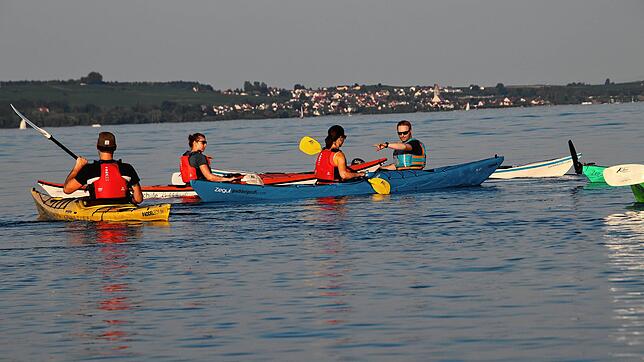 Die warmen Temperaturen locken viele Kajakfahrer auf den Bodensee. Hier eine Kursgruppe, die abends bei Konstanz eine Ausfahrt unternimmt.