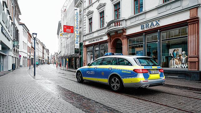 Ein Polizeiwagen fährt am frühen Nachmittag durch die nahezu menschenleere Hauptstraße, die eine Fußgängerzone und beliebte ...