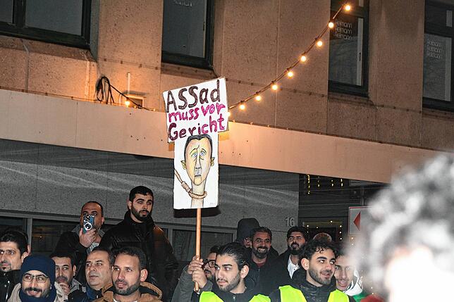 Auch dieses Schild war bei der Kundgebung zu sehen: die Forderung, dass Baschar al-Assad vor Gericht kommen müsse.