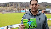 Florian Liebegott zeigt auf dem Sportgelände des FC Steißlingen ein Bild, das ihn als kleinen Jungen beim Fußball spielen für seinen ...