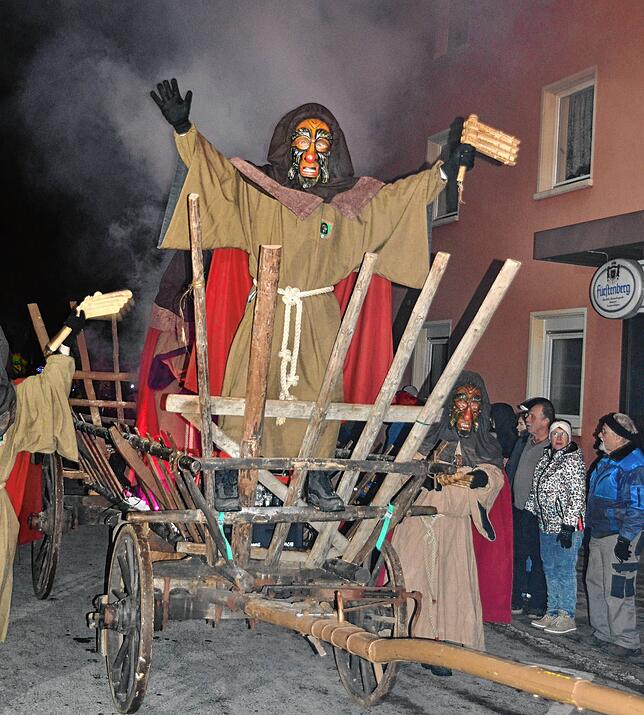 Die Zunft der Blumberger Eichberggeister beherrscht mit ihrem rustikalen Strohwagen und viel Nebel die Straße beim Nachtumzug.