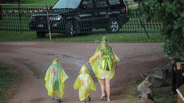 Eine Familie macht sich beim Regen auf den Weg zum Parkplatz. Bild: Guy Simon