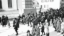 Bei einer Fasnacht in den 1930er-Jahren lag Schnee. Der Umzug geht am Kriegerdenkmal vorbei.