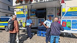 Das Polizeipräsidium Ravensburg informiert in den Sommerferien auf dem Wochenmarkt in Pfullendorf. Die Beamten Andreas Blender (l.) und ...