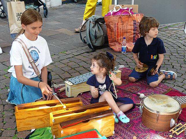 Sie trommeln und vergnügen sich mit den verschiedenen Musikinstrumenten der Kinderkantorei Hochrhein.
