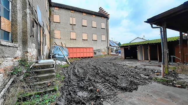 Der Innenhof, in dem ein Bagger Abdrücke im Boden hinterlasse hat.