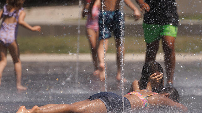Es ist viel zu heiß in Italien. Hier kühlen sich Kinder in einem Brunnen ab.