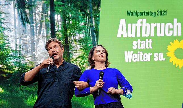 Die beiden Grünen-Bundesvorsitzenden Robert Habeck und Annalena Baerbock haken einander unter beim Bundesparteitag der Grünen.
