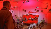 Der ehemalige Landrat Lothar Wölfle betrachtet die Installation der bizarren Märchentiere von Ingrid Butschek auf dem roten Sofa. Foto: ...