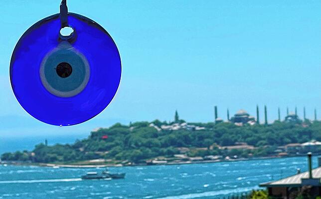 Nazar Boncugu heißt das Amulett auf Türkisch: Perle gegen den bösen Blick. Im Hintergrund ist die Altstadt-Halbinsel von Istanbul zu sehen.