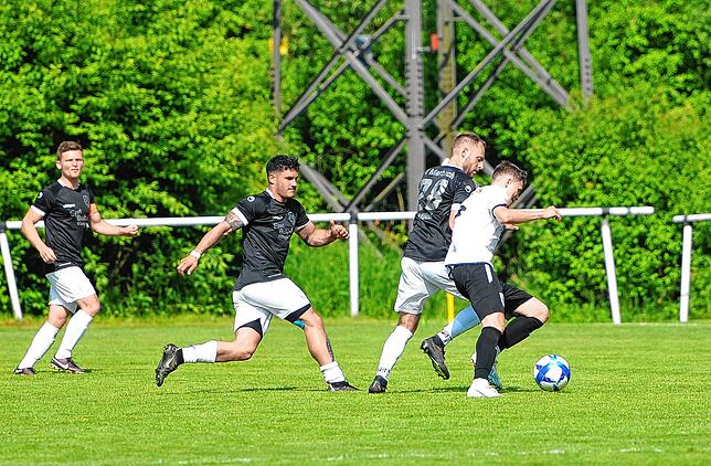 Schwerer Stand für Schonachs Fabian Klausmann (weißes Dress) gegen die Marbacher. Gleich zwei Gegenspieler lauern auf einen Ballverlust.
