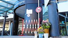 Der Haupteingang des Klinikums Friedrichshafen. Links die Drehtür, rechts die Blumen, die an die verstorbene Oberärztin erinnern.