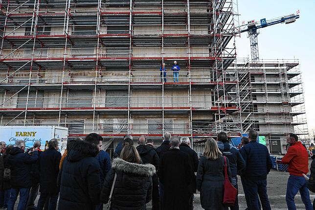 Dutzende sind gekommen, um gemeinsam mit den Handwerkern das Richtfest für das neue Pflegezentrum zu halten. Auf dem Gerüst steht ...
