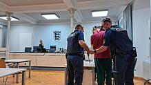 Justizbeamte bringen den 66-Jährigen in den Gerichtssaal. Wegen einer vorherigen Verurteilung befindet er sich bereits in Haft.