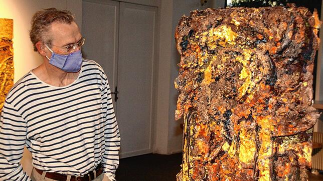 Ein Besucher betrachtet eine Metallskulptur von Erwin Rehmann.