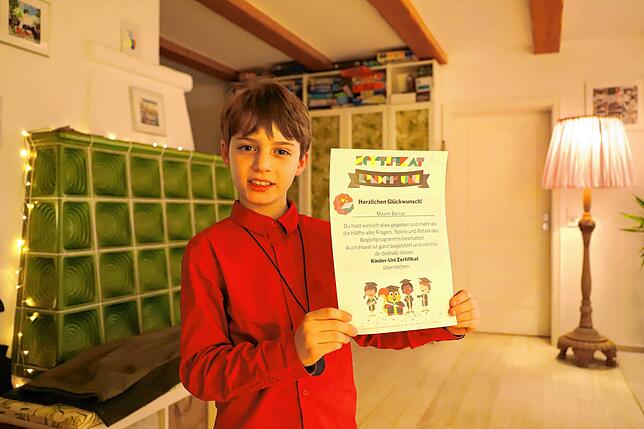 Maxim Berner zeigt stolz eine seiner vielen Bestätigungen für Kurse, die er belegt hat. Dieses stammt von einer Kinder-Uni.