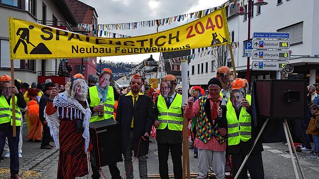 Der Hasenrat mit Masken der Gemeinderäte inszeniert mitten im Umzug verschiedene Spatenstiche.