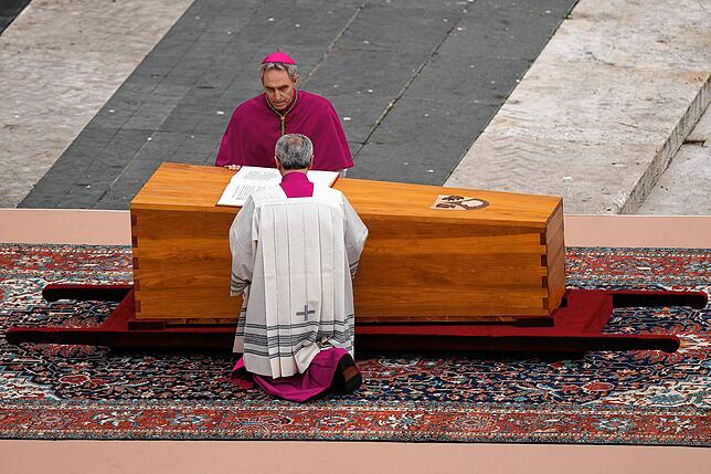 Georg Gänswein (oben), Kurienerzbischof und langjähriger Privatsekretär des verstorbenen emeritierten Papst Benedikt XVI., kniet am Sarg ...