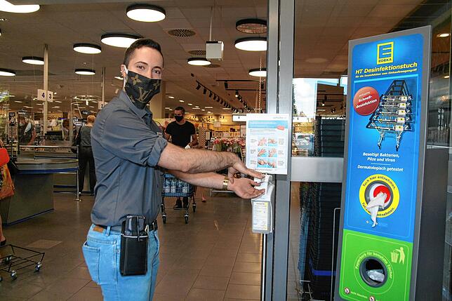 Pere Gonzalez, einer der Stellvertreter bei Edeka in Jestetten, zeigt, wie es geht. Am Eingang stehen Desinfektionsmittel für die Hände ...