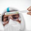 Ein Mitglied des medizinischen Personals steckt ein Wattestäbchen nach einem PCR-Abstrich zum Test auf Covid-19 in ein Röhrchen ...