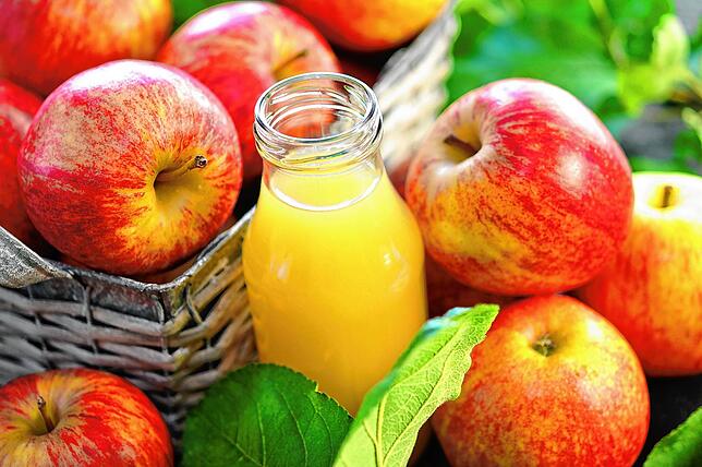 Wichtiges Exportgut im Bodenseegebiet: Äpfel liegen neben einer Saftflasche.