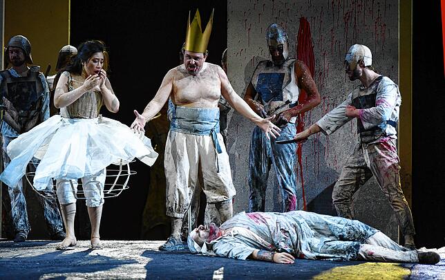 Elvira (Guanqun Yu) und Don Carlo (Franco Vassallo) – ein König mit Pappkrone und nacktem Oberköper.