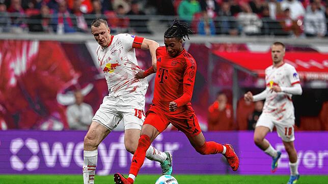 Leipzigs Lukas Klostermann (l) und Münchens Michael Olise kämpfen um den Ball. FC Bayern verpasst einen Sieg in Leipzig und vertagt ...